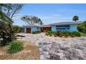 Charming home showcasing a meticulously landscaped front yard and a brick driveway at 4381 Poinsettia Dr, St Pete Beach, FL 33706
