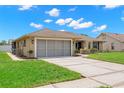 A tan single-story house with a well-manicured lawn and a gray two-car garage at 4530 Zack Dr, New Port Richey, FL 34653