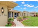 Close up of the front entrance with decorative landscaping and a brick paver walkway at 4530 Zack Dr, New Port Richey, FL 34653