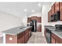 A kitchen showcases granite counters, stainless steel appliances, and stylish brown cabinetry at 4902 Grist Mill Ct, Wimauma, FL 33598