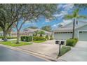 Charming home with a three-car garage, mature landscaping, and well-maintained lawn at 5814 Heronpark Pl, Lithia, FL 33547