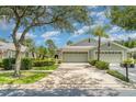 Charming home with a three-car garage, mature landscaping, and well-maintained lawn at 5814 Heronpark Pl, Lithia, FL 33547