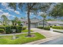 Charming home with a three-car garage, mature landscaping, and well-maintained lawn at 5814 Heronpark Pl, Lithia, FL 33547