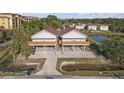An up close exterior of this two-story light gray home with a brown roof, concrete driveway and wooden deck at 6602 S Sherrill St, Tampa, FL 33616