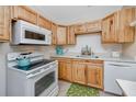 Cozy kitchen featuring wood cabinets, white appliances, and a bright countertop at 8584 111Th St # 308, Seminole, FL 33772