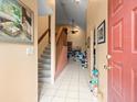 Inviting foyer with tiled floors, staircase, and a view into the living area at 8731 Huntfield St, Tampa, FL 33635