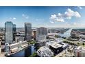 Scenic aerial view showcases the city skyline, river, and architectural design under a partly cloudy sky at 111 S Ashley Dr # 2705, Tampa, FL 33602
