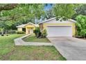 Charming yellow home with white garage door, stone accents, and inviting landscaped front yard at 1110 Mercer Loop, Plant City, FL 33567