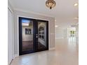 Open entryway features neutral tile flooring and glass paneled double doors into the home at 11225 4Th E St, Treasure Island, FL 33706