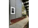 Exterior detail of gray siding with a white framed window and manicured mulch bed at 11941 Skylake Pl # 11941, Temple Terrace, FL 33617