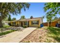 Inviting single-Gathering home with a yellow exterior, black shutters, and well-maintained lawn at 1320 Oak Valley Dr, Seffner, FL 33584