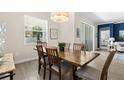 Bright dining room with natural light, wood table and chairs, and neutral color scheme at 17418 Holly Well Ave, Wimauma, FL 33598