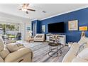 Comfortable living room featuring stylish decor, neutral-toned furniture, and access to the backyard patio at 17418 Holly Well Ave, Wimauma, FL 33598