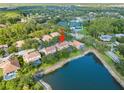 An aerial view of a neighborhood featuring homes surrounding a large pond, showing community amenities at 18004 Avalon Ln, Tampa, FL 33647