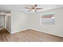 Bright bedroom with wood-look floors, ceiling fan, and a window with natural light at 1826 Cadillac Cir, Tampa, FL 33619