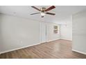 Spacious living room with updated floors, a ceiling fan, and a rear entry door at 1826 Cadillac Cir, Tampa, FL 33619