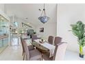 Open dining room with high ceilings, decorative chandelier, and views into the living area at 18561 Winding Oaks Blvd, Hudson, FL 34667