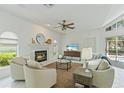 Cozy living room with a tiled fireplace, comfortable seating, and access to the outdoor pool area at 18561 Winding Oaks Blvd, Hudson, FL 34667