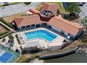 Aerial view of community pool surrounded by lounge chairs and lush landscaping at 244 Mariner Dr, Tarpon Springs, FL 34689