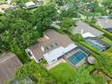 Aerial view of property featuring screened-in pool, lush landscaping, and neutral roof at 4209 Winding Willow Dr, Tampa, FL 33618