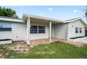 Inviting front porch with brick accents and neutral tones, creating a warm and welcoming entrance at 4414 Royal Oak Ln, New Port Richey, FL 34653