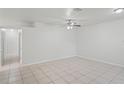 Open-concept living room boasts neutral tile flooring, a ceiling fan, and seamless transition to other spaces at 456 Summer Sails Dr, Valrico, FL 33594