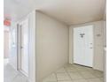 Condo hallway with tile flooring, unit number 1501, and a view of the fire extinguisher at 5200 Brittany S Dr # 1501, St Petersburg, FL 33715