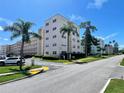 Exterior view of a condo complex surrounded by lush greenery and a well-maintained street at 5623 80Th N St # 406, St Petersburg, FL 33709