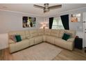 Bright living room featuring a plush sectional sofa, neutral tones, and wood-look laminate flooring at 5628 2Nd N Ave, St Petersburg, FL 33710