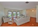 Cozy living room with hardwood floors, neutral walls, and an abundance of natural light at 608 Fort Duquesna Dr, Sun City Center, FL 33573