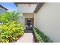 Inviting front porch with a comfortable bench, lush landscaping, and a brick walkway at 6327 Positano Ct, Sarasota, FL 34243