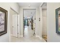 Bright hallway with tile flooring, neutral walls, and doorways leading to various rooms at 6327 Positano Ct, Sarasota, FL 34243