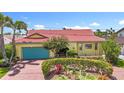 Charming home showcasing beautiful brickwork, tropical landscaping, and a striking red tile roof at 760 Capri Blvd, Treasure Island, FL 33706