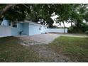 Landscaped yard, light blue exterior of a charming single-Gathering home at 8405 N Willow Ave, Tampa, FL 33604