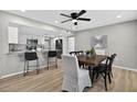 Modern dining area featuring stylish chairs, an elegant ceiling fan, and seamless flow to the kitchen at 8939 90Th Ave, Seminole, FL 33777