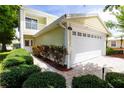 Bright home with a two-car garage, beautiful landscaping, and a cozy balcony, creating an inviting outdoor space at 932 Woodbridge Ct, Safety Harbor, FL 34695