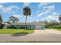 Light blue home with a well-maintained lawn and mature palm trees; perfect for Florida living at 105 E North Branch Rd, Ruskin, FL 33570