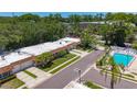 Aerial view of a well-maintained community featuring a sparkling pool, lush landscaping, and tidy homes at 1102 Cara Dr, Largo, FL 33771