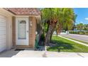 Inviting front entrance with a charming white door and stone accents, surrounded by lush landscaping at 1102 Cara Dr, Largo, FL 33771