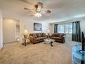 Cozy living room featuring comfortable seating, a ceiling fan, and a view into the bathroom at 1102 Cara Dr, Largo, FL 33771