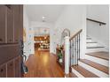 Bright foyer featuring hardwood floors, staircase with iron railing, and views into the kitchen and dining area at 115 W Hiawatha St, Tampa, FL 33604