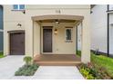 Charming front porch with detailed ceiling, ceiling fan, dark wood door, and elegant landscaping at 115 W Hiawatha St, Tampa, FL 33604