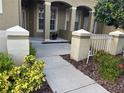 View of the front porch with decorative columns and landscaped walkway at 12749 Aston Creek Dr, Tampa, FL 33626