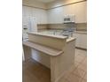 Spacious kitchen featuring white cabinets and a peninsula with a bar top at 12749 Aston Creek Dr, Tampa, FL 33626