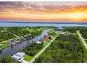 Stunning aerial view of waterfront home on canal with beautiful sunset backdrop at 13045 Irwin Dr, Port Charlotte, FL 33953