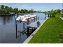 This dock features a pontoon boat, along with a chair for relaxing by the water at 13045 Irwin Dr, Port Charlotte, FL 33953