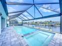 Screened-in pool and hot tub overlooking canal offer a private backyard oasis at 13045 Irwin Dr, Port Charlotte, FL 33953