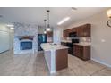 Lovely kitchen with stainless steel appliances, center island, tile backsplash, and adjacent living area with fireplace at 14524 Dunrobin Dr, Wimauma, FL 33598
