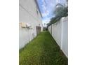 Narrow grassy area between the house and a white fence, offering privacy and space at 1521 Atami Ct, Wesley Chapel, FL 33544