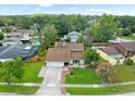 Aerial view of a beautiful single-Gathering home with lush green surroundings, including a well-maintained lawn at 15711 Springmoss Ln, Tampa, FL 33624